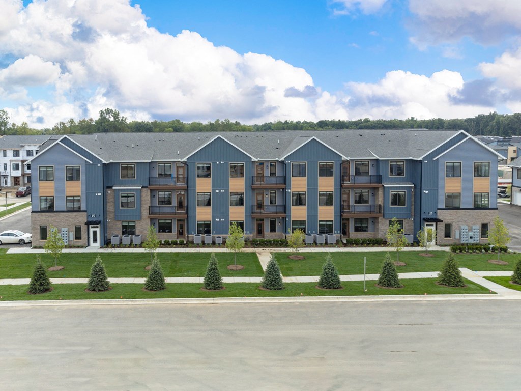 an exterior view of an apartment building with a parking lot